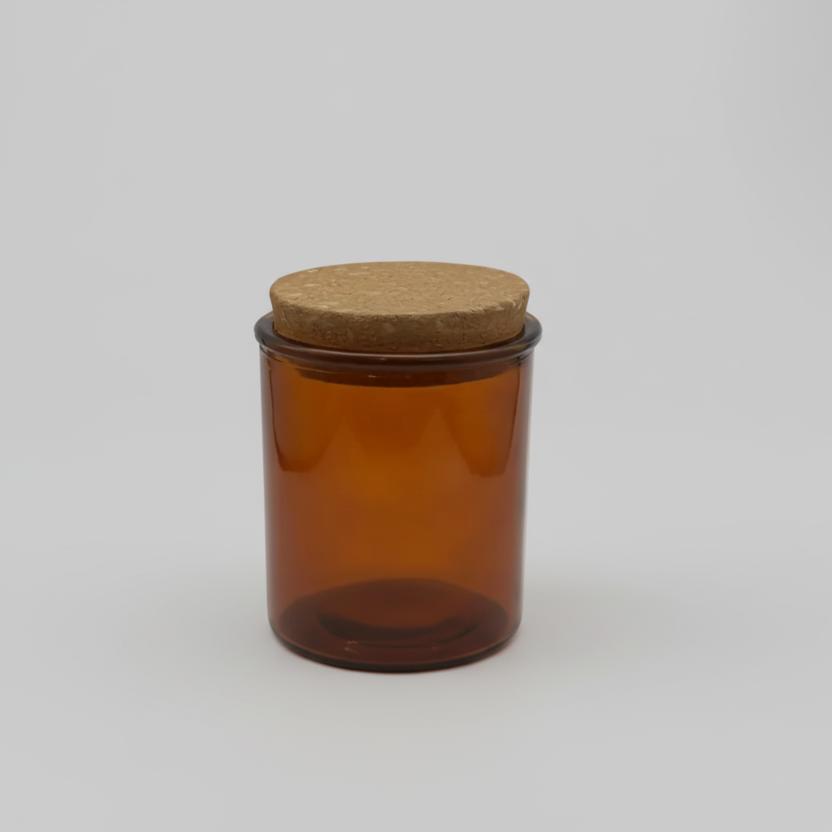 Amber glass jar with a cork lid on a white background