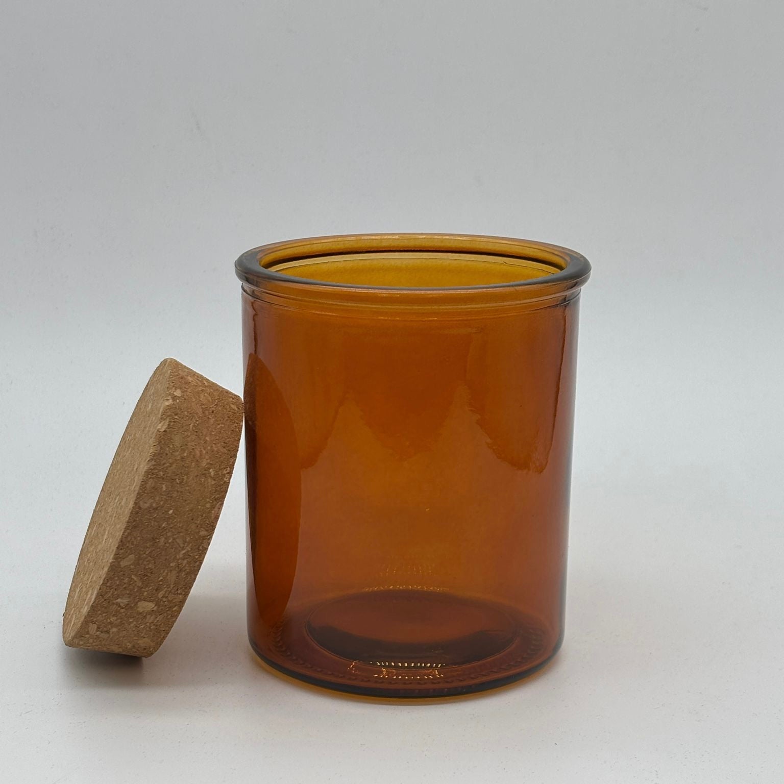 Amber glass jar with a wooden lid on a white background, apothecary jar